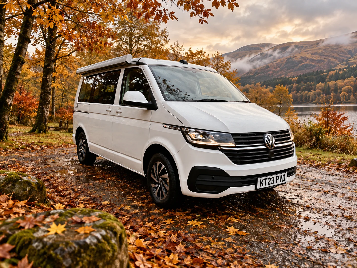 A white VW campervan beside a Scottish loch in autumn
